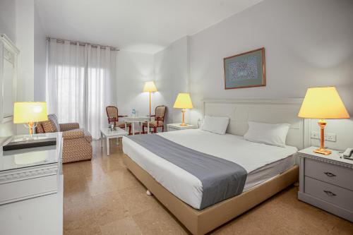 马达巴马达巴大酒店的卧室配有一张床和一张桌子及椅子