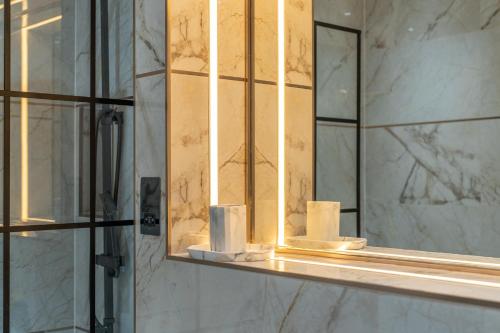 伦敦Brand New London Luxury House - Sleeps 8的浴室镜子,在架子上摆放着卫生纸