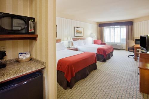 阿斯托里亚阿斯托里亚智选假日套房酒店的酒店客房设有两张床和电视。
