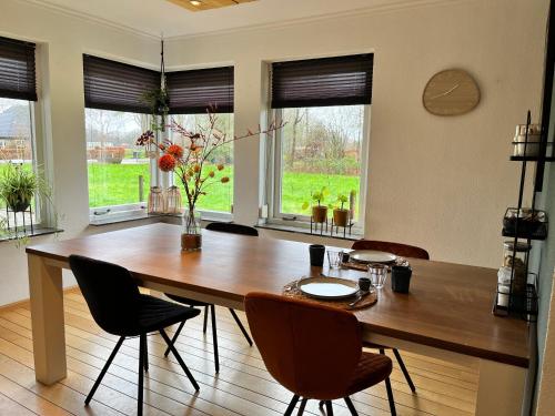 GlaneBed and Breakfast De Beekhoek的一间带木桌和椅子的用餐室