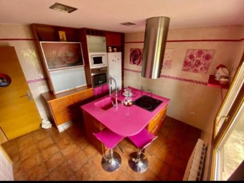 苏安塞斯Alojamientos Marte casa rural的带炉灶的厨房内的粉红色桌子