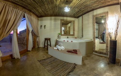 布隆方丹Emoya Basotho Lodge的带浴缸和盥洗盆的大浴室