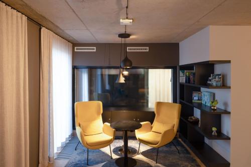 慕尼黑numa I Stark Rooms & Apartments的一间带两把椅子和一张桌子的用餐室