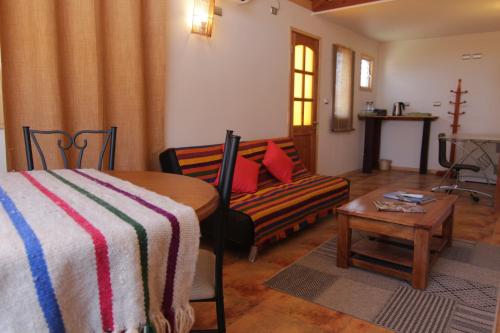科皮亚波Hotel El Bramador的客房设有床、沙发和桌子。