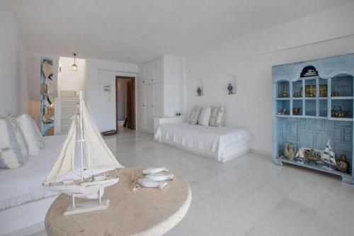 斯派赛斯Spetses Sea View Luxury House的白色的客厅,桌子上放着玩具帆船