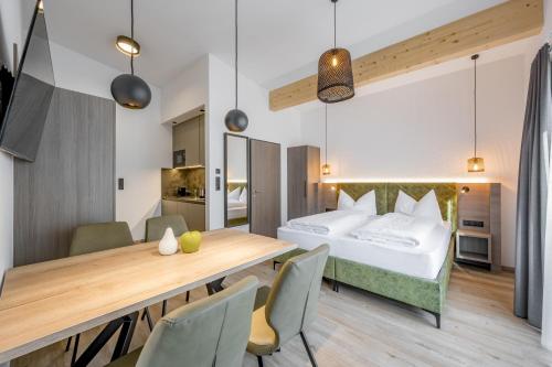 索尔登Camping Sölden Apartments的酒店客房带一张床、一张桌子和椅子