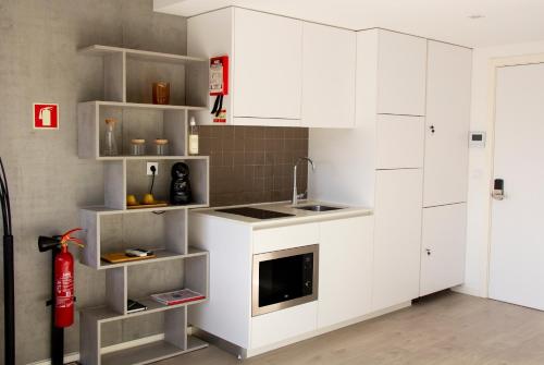阿威罗Casa das Falcoeiras - Estúdio com terraço privado的厨房配有白色橱柜和红色消防栓