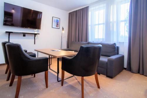 华沙Warsaw Apartments - Apartamenty Sadyba的客厅配有桌椅和沙发