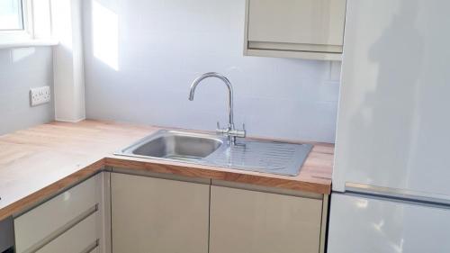 海尔Sandy Bay Apartment, St Ives Bay, Hayle的厨房配有水槽和冰箱