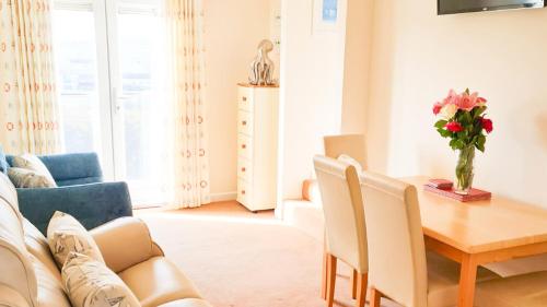 海尔Sandy Bay Apartment, St Ives Bay, Hayle的客厅配有桌子和沙发