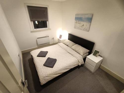 伦敦Lovely 2 bedroom serviced apartment in London的一间卧室配有一张床,上面有两条毛巾