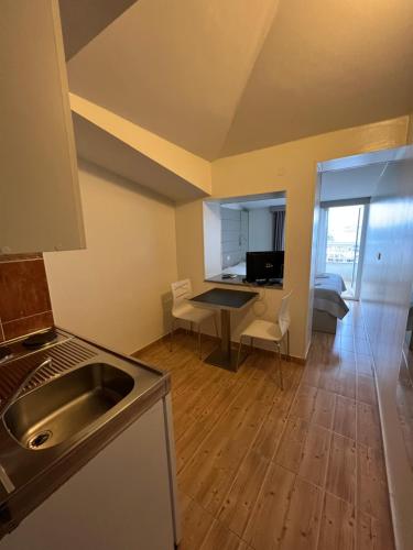 斯普利特西蒙尼公寓的厨房以及带水槽和桌子的客厅。