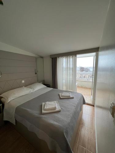 斯普利特西蒙尼公寓的一间卧室配有一张床,上面有两条毛巾