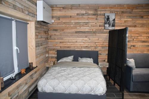 BoligniesLogement in wood (400 mètres de Pairi Daiza)的一间卧室设有一张床和木墙