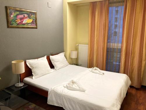 布加勒斯特塔尼亚 - 法兰克福酒店的一间卧室,床上有白色的鞋