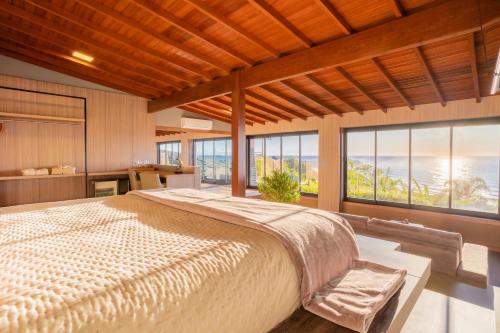 普腊亚罗萨Pousada Rêmora的一间卧室设有一张大床和大窗户
