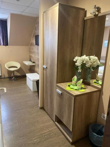 尼尔巴托尔绝对酒店及旅馆的浴室设有镜子和花卉,位于柜台上