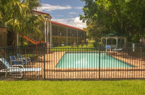 黄金海岸玛拉汽车旅馆的一个带椅子的围栏后面的游泳池和游乐场