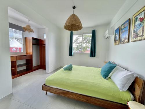 勒迪亚芒Villa en bord de mer, vue mer au Diamant的一间位于客房内的带绿床的卧室