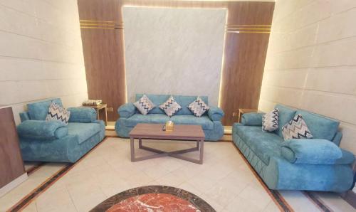 Ḩayy aş Şāliḩīyahسارة للشقق المفروشة - الحمدانية جدة的客厅配有2张蓝色的沙发和1张桌子