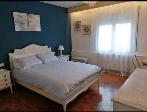 帕拉莫斯Spacious family flat centrally located.的一间卧室设有一张床和蓝色的墙壁