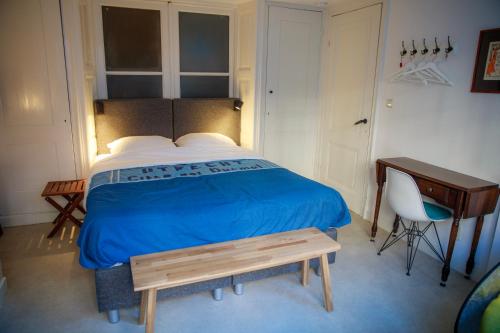 乌得勒支Obrecht Welcome的一间卧室配有一张带蓝毯的床和一张书桌