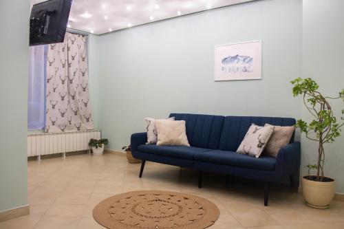 切佩拉雷米特奥家庭酒店的客厅配有蓝色的沙发和电视
