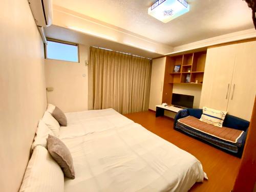 台中市逢甲猪小窝的卧室配有一张白色的大床和一张沙发。