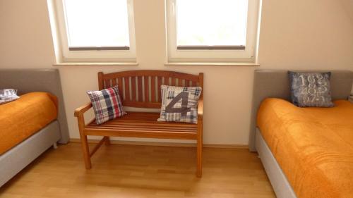 维埃雷格Haus TimpeTe am Breetzer Bodden的客房设有两张床、一张带枕头的木椅