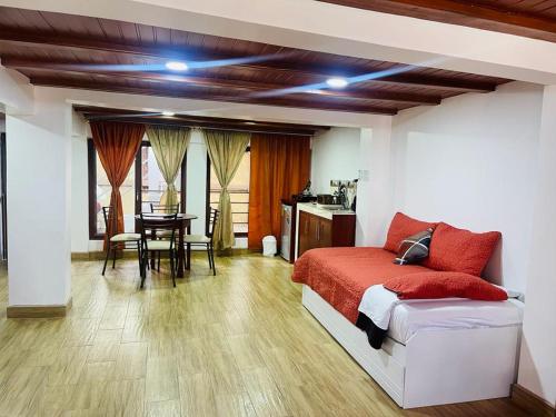 巴尼奥斯Hermoso apartamento en Baños de Agua Santa的一间卧室配有一张床,另一间用餐室配有桌子