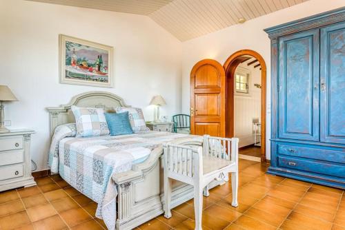 萨尔加LA CALMA Espectacular villa con jardín y piscina en Menorca的卧室配有白色的床和蓝色橱柜。