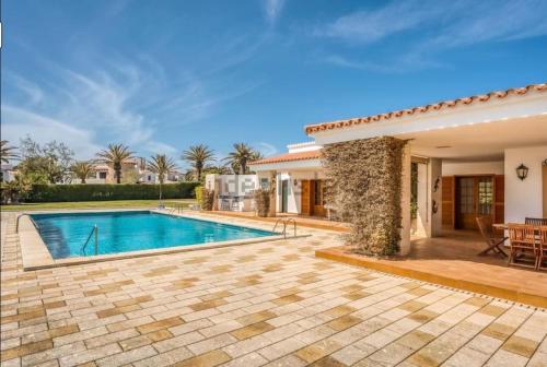 萨尔加LA CALMA Espectacular villa con jardín y piscina en Menorca的一个带游泳池和庭院的别墅