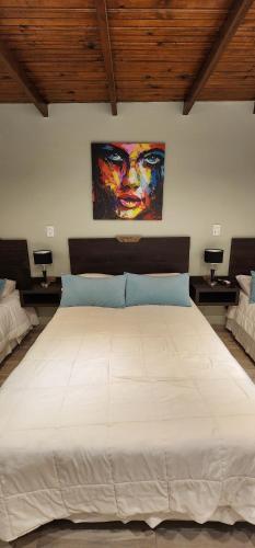 帕索德洛斯利布雷斯Nomades Apartamentos的卧室配有一张白色大床,墙上挂有绘画作品