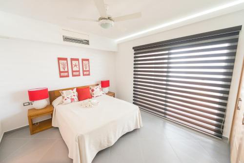 拉斯特拉纳斯Aligio Apart-hotel & Spa - Las Terrenas的一间卧室设有一张床和一个大窗户