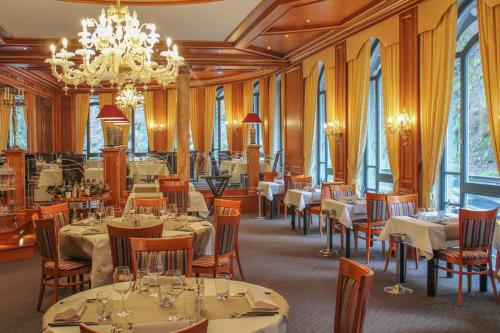 克莱沃Koener Hotel & Spa的一间带桌椅和吊灯的餐厅