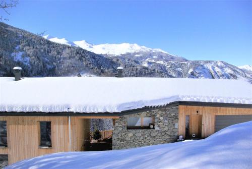 瓦尔梅尼耶Chalet le 1000 Thabor的山地雪覆盖的房子