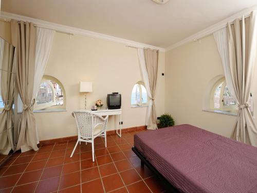 阿特拉尼拉伊多莫斯公寓的一间卧室配有一张床和一张书桌及电视