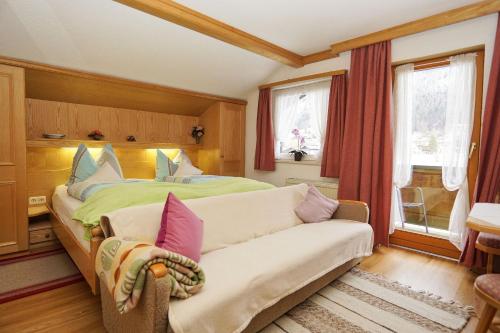 雷特温克尔Haus Regner的一间卧室配有一张床、一张沙发和一个窗口
