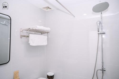 顺化Chi's Homestay & Coffee的带淋浴和卫生间的白色浴室