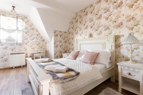考斯赛力克Apartament SWEET HOME的一间卧室配有一张粉红色花卉壁纸的床
