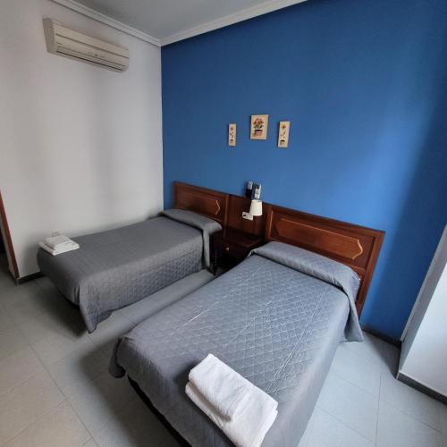 马德里泛美旅馆的一间设有两张床和蓝色墙壁的客房