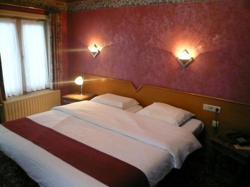 洛克伦拉巴拉卡酒店的一间卧室配有一张大床,墙上有两盏灯