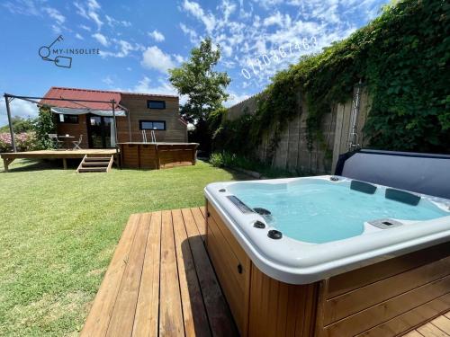 艾格-莫尔特myinsolite - Tiny-house, jacuzzi, brasero, piscine的庭院甲板上的热水浴缸