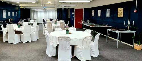 埃斯基尔斯蒂纳Hotell Tre Systrar的用餐室配有白色的桌子和白色的椅子