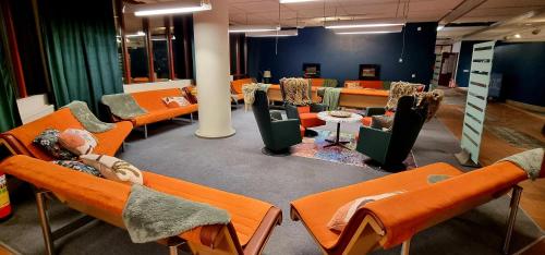 埃斯基尔斯蒂纳Hotell Tre Systrar的一间设有一排橙色椅子和桌子的房间