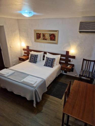 埃尔瓦斯Residencial Antonio Mocisso Guesthouse的卧室配有一张白色的大床和一张桌子