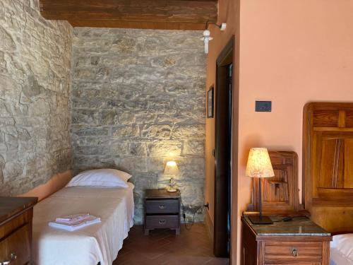 Monte BenedettoLa Busca Country House的一间卧室设有两张床和石墙
