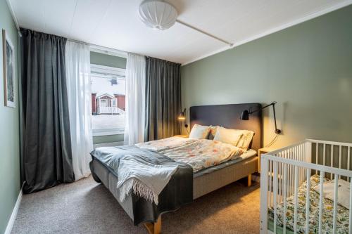 DomsjöSpacious Villa located in Beautiful High Coast的一间卧室配有一张床、一张婴儿床和一扇窗户。