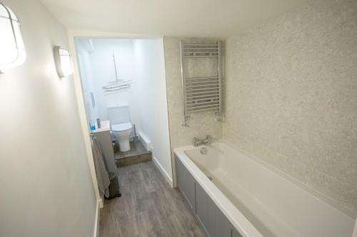卡迪根Castle Cottage的白色的浴室设有浴缸和卫生间。