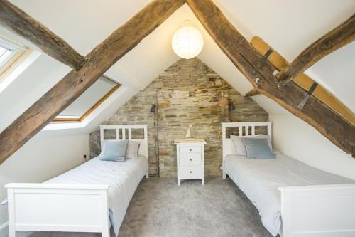 卡迪根Castle Cottage的阁楼间设有两张床铺和外露横梁